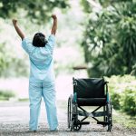Physical therapy senior woman with wheelchair in the park